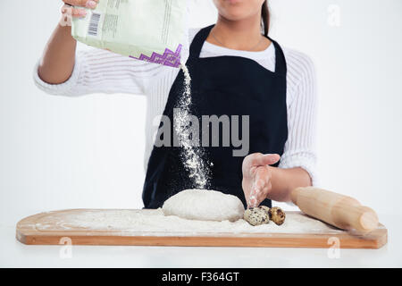 Closeup portrait of a baker preparing dough for pastry isolated on a white background Stock Photo