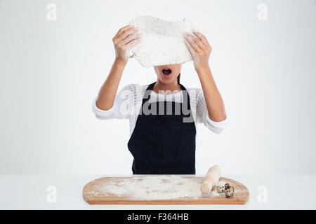 Portrait of a shocked woman preparing dough for pastry isolated on a white background Stock Photo