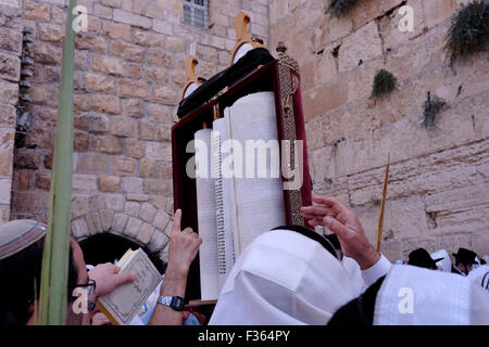 Jerusalem, Israel. 30th September, 2015. Ultra-Orthodox Jewish worshipers raising the Torah Jewish bible during the annual Cohanim prayer priest's blessing during Sukkot or the feast of the Tabernacles, holiday at the Western Wall in the old city of Jerusalem on September 30 2015. Tens of thousands of Jews make the week-long pilgrimage to Jerusalem during Sukkot, which commemorates the desert wanderings of Israel after their exodus from Egypt. Credit:  Eddie Gerald/Alamy Live News Stock Photo