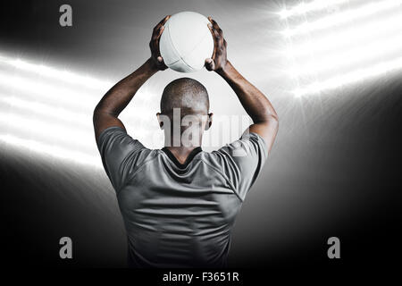 Composite image of rear view of athlete throwing rugby ball Stock Photo