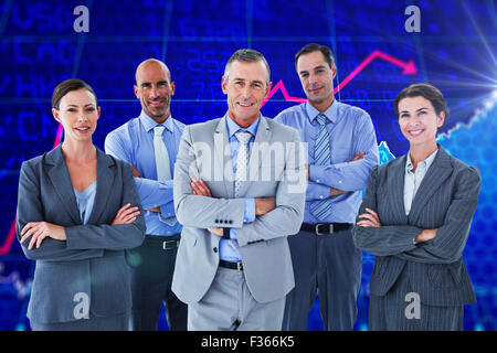 Composite image of business team working happily together on laptop Stock Photo