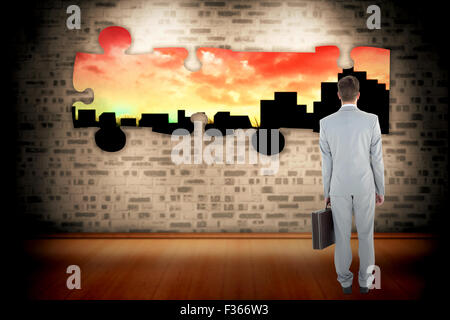 Composite image of businessman holding his briefcase Stock Photo