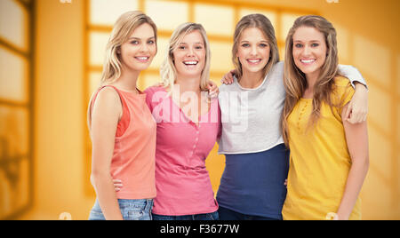 Composite image of four friends standing beside each other and smiling Stock Photo