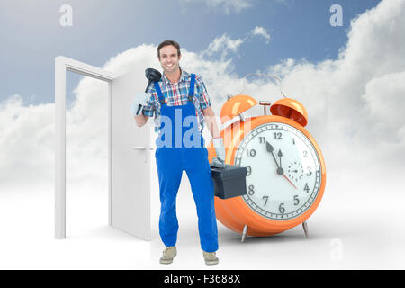 Composite image of portrait of plumber holding plunger and tool box Stock Photo