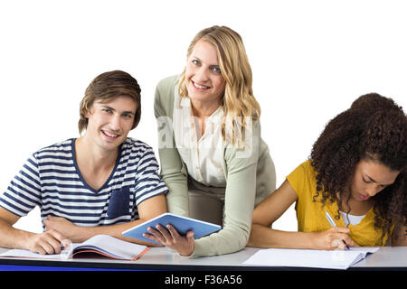 Composite image of teacher helping student in class Stock Photo