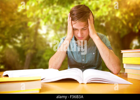 Composite image of student sitting in library reading Stock Photo