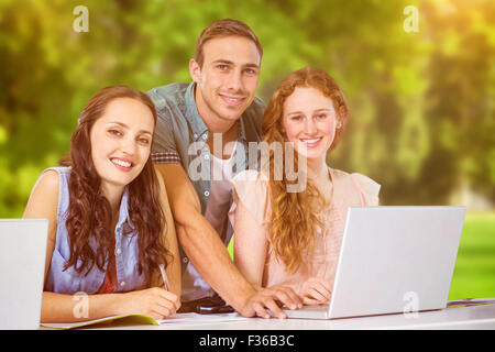 Composite image of fashion students using laptop Stock Photo