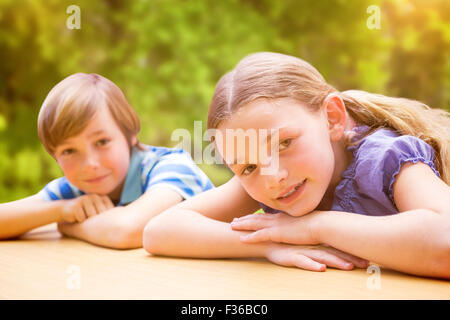 Composite image of cute pupils resting on their arms Stock Photo