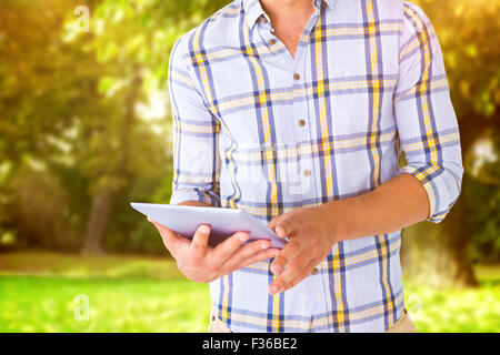 Composite image of young student using tablet pc Stock Photo