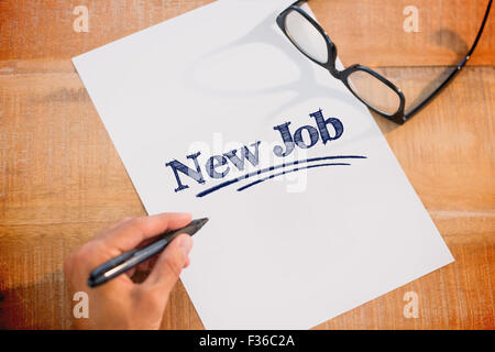 New job against left hand writing on white page on working desk Stock Photo
