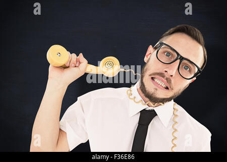 Composite image of geeky businessman being strangled by phone cord Stock Photo
