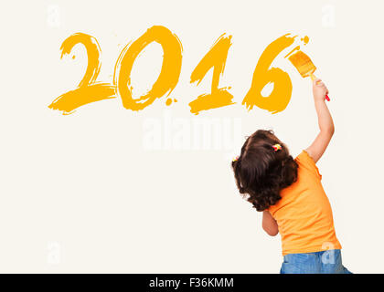 Cute little girl drawing new year 2016 with painting brush on wall background Stock Photo