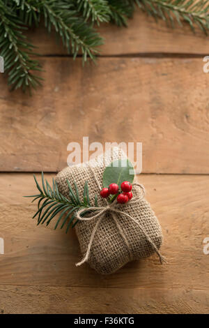 Natural holiday wrapped gift with holly berries Stock Photo