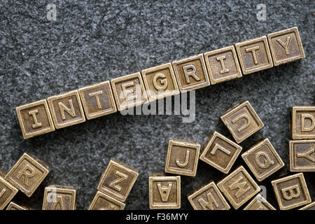 integrity word made from metallic blocks on blackboard surface Stock Photo