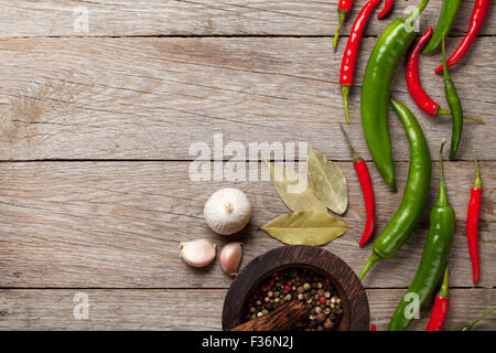 Chili pepper, peppercorn, garlic and bay leaves on wooden table with copy space Stock Photo