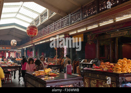 People pray and offer incense inside Guandu Temple, Beitou District, Taipei City, Taiwan Stock Photo