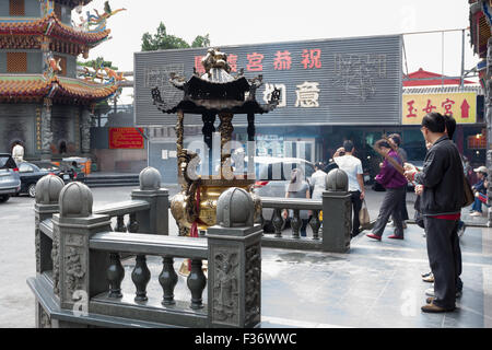 People pray and offer incense outside Guandu Temple, Beitou District, Taipei City, Taiwan Stock Photo