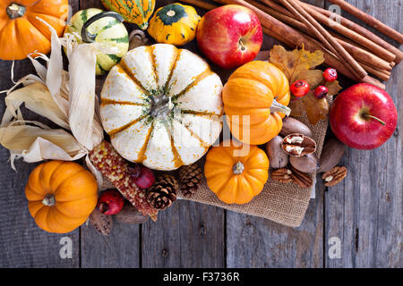 Pumpkins, nuts, indian corn and apples on a rustic table overhead corner frame with empty space Stock Photo