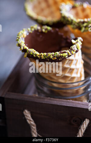 Chocolate pistachio waffle cones in jars ready to serve ice cream Stock Photo