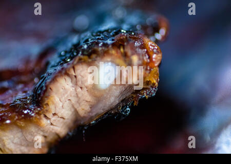 Macro closeup of well cooked chargrilled ribs with sticky glaze and crispy coating Stock Photo