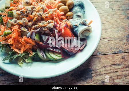 Plate of fish and salad on a wooden table Stock Photo