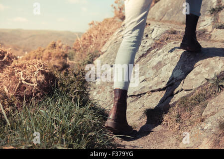 Closeup on a young woman's feet and legs as she is trekking in the mountains Stock Photo