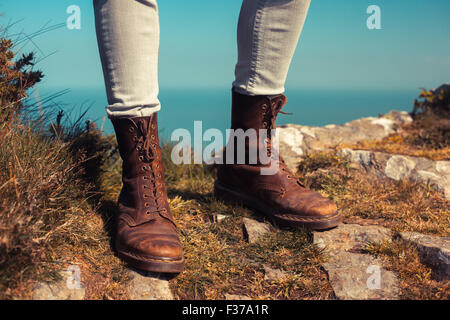 Closeup on a young woman's feet and legs as she is trekking in the mountains Stock Photo