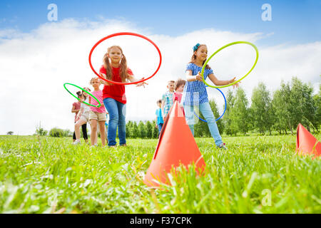 Happy girls and boys throwing colorful hoops Stock Photo