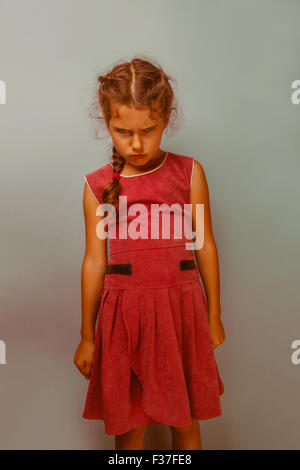 Girl European appearance decade  angry frowns blue background re Stock Photo
