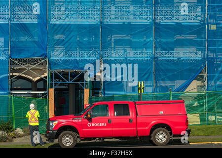 Construction worker and red truck in front of building under construction-Victoria, British Columbia, Canada. Stock Photo