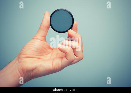 A hand is holding circular polarizer filter Stock Photo