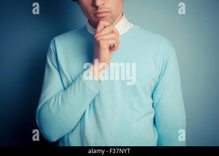 Young man is standing and thinking Stock Photo