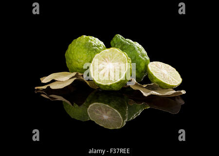 Dried bergamot leaves and fresh fruits isolated on black background. Culinary cooking, tropical fruit bergamot orange. Stock Photo