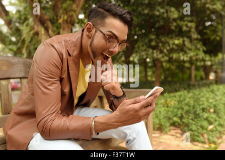 Asian , Man , Indian Ethnicities , Smart Phone , Casual Clothing , Outdoor . Stock Photo