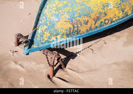 Old rowboat lays on sandy beach. Gulf of Finland, Russia Stock Photo