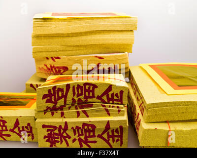 Ghost Money - paper made to resemble money and burned as an offering to the dead  on white background Stock Photo