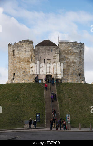 People (visitors) walking up & down steep steps to Clifford's Tower ( historic hilltop castle ruins & landmark - York, North Yorkshire, England, UK. Stock Photo