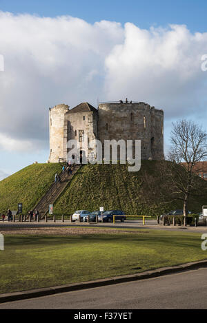 Sunny winter day & visitors are walking up & down steep steps at Cliffords Tower (well-known historic landmark, York, North Yorkshire, England, UK). Stock Photo