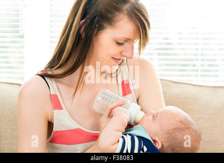 mother feeding baby with milk from a bottle Stock Photo