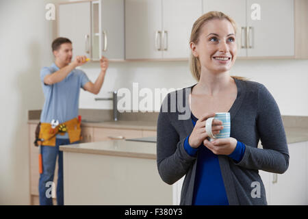 Woman Standing In New Luxury Fitted Kitchen Stock Photo