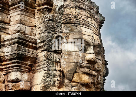 Giant stone carved face at the ancient Bayon temple. Angkor Archaeological Park, Siem Reap Province, Cambodia. Stock Photo