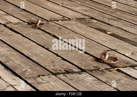 Old wooden deck and a hatch with two rusty metal handles. Stock Photo