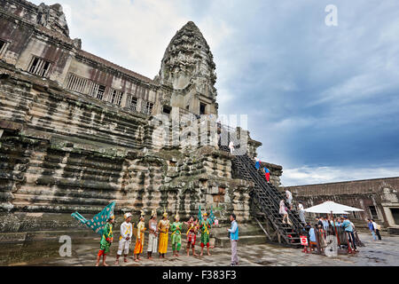 People in traditional Khmer costumes at the access to the top tier of Angkor Wat temple. Angkor Archaeological Park, Siem Reap Province, Cambodia. Stock Photo