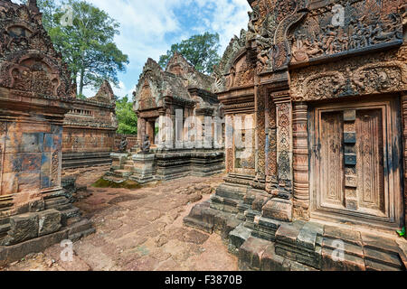 Stone buildings of the ancient Banteay Srei temple covered with intricate carvings. Angkor Archaeological Park, Siem Reap Province, Cambodia. Stock Photo
