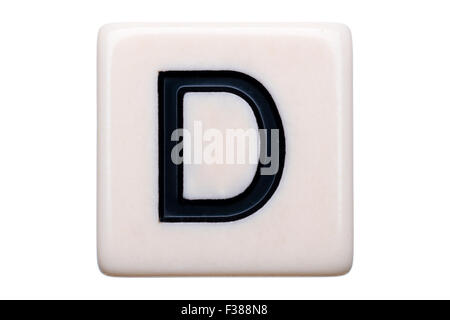 A macro shot of a game tile with the letter D on it on a white background. Stock Photo