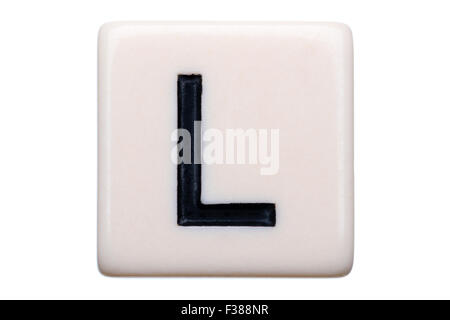 A macro shot of a game tile with the letter L on it on a white background. Stock Photo