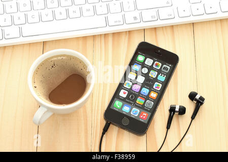 KIEV, UKRAINE - APRIL 15, 2015:iPhone 5s Space Gray with coffee and keyboard on wooden background. Stock Photo