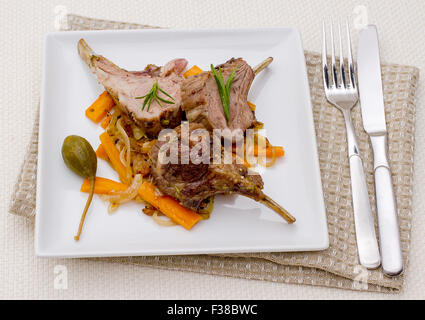 Grilled racks of lamb with onion, garlic and capers, top view Stock Photo