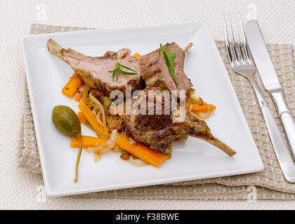 Grilled racks of lamb with carrot, garlic and capers, top view Stock Photo