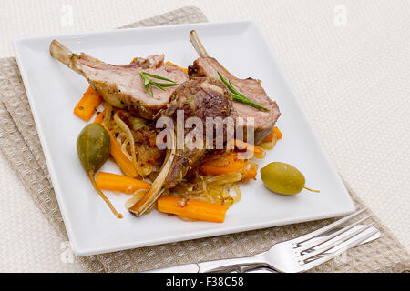 Grilled racks of lamb with olive, capers and carrot, top view Stock Photo